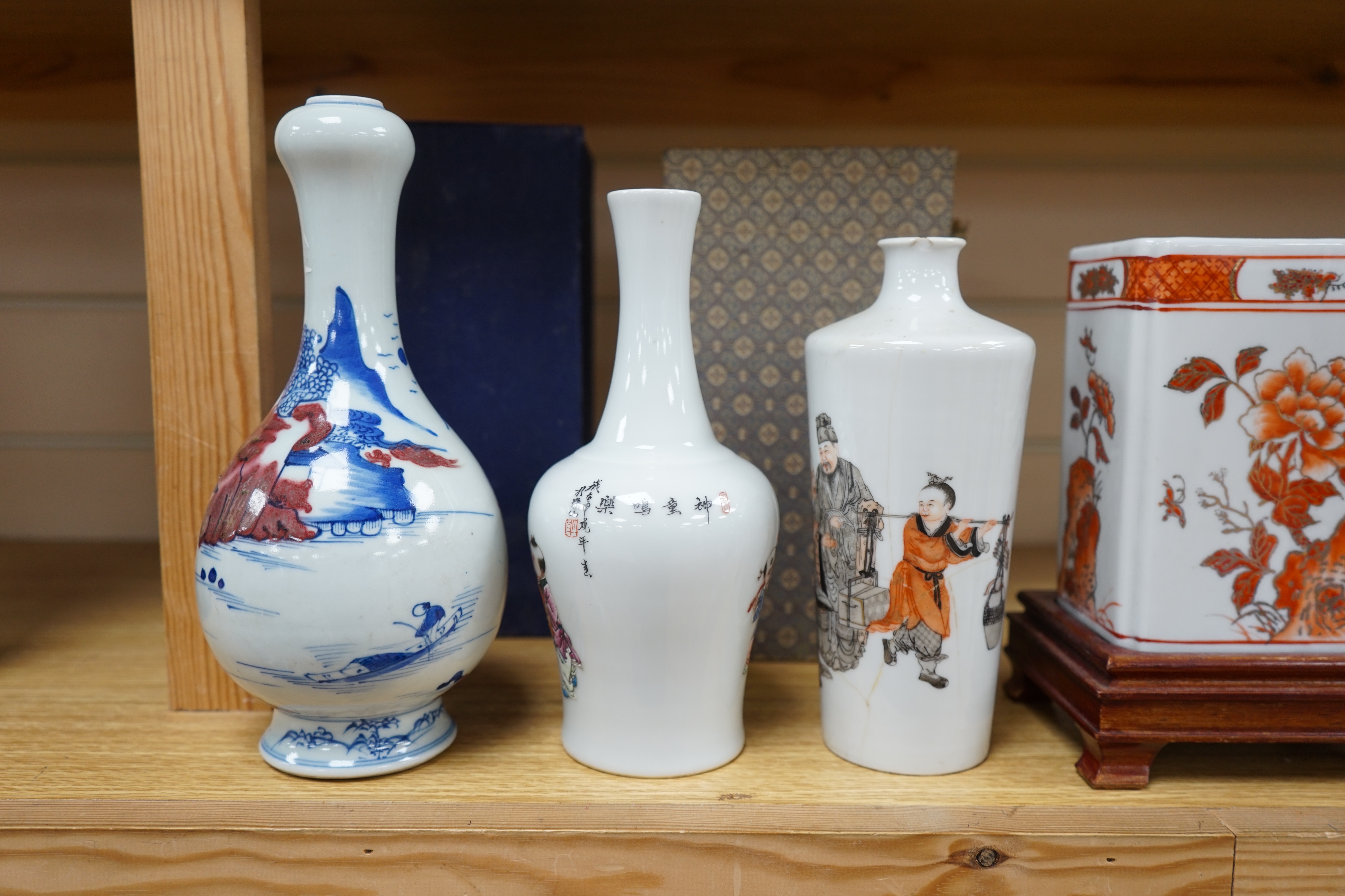 Two Chinese enamelled porcelain figure decorated vases, an underglaze blue and copper read garlic neck vase, and a rectangular jar with wood stand Condition - One vase cracked and chipped the rectangular jar lacking cove